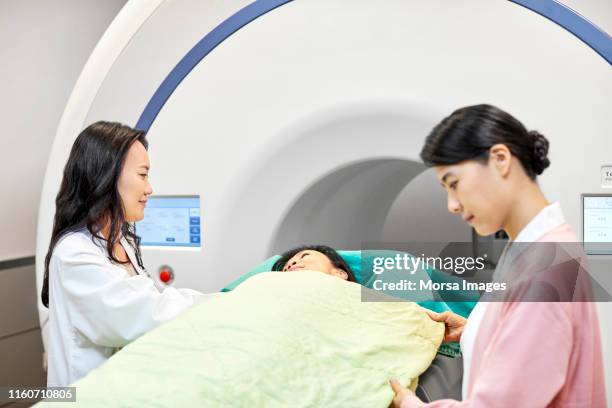 female radiologists preparing patient for mri scan - cat scan stock-fotos und bilder