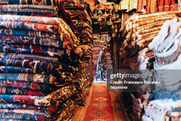 cappadocia, woman walking in a colorful carpet market. turkey - cappadocia stock pictures, royalty-free photos & images