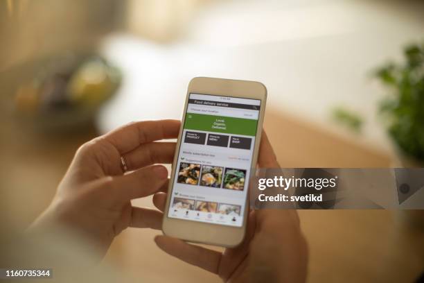 vrouw met behulp van maaltijd delivery service via mobiele app. - demanding stockfoto's en -beelden