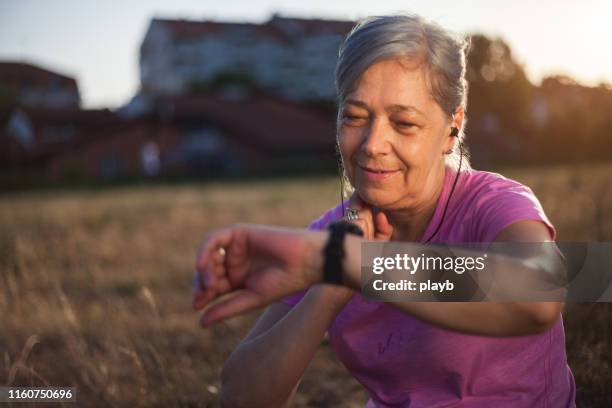 senior woman checking her pulse after exercise - carotid artery stock pictures, royalty-free photos & images