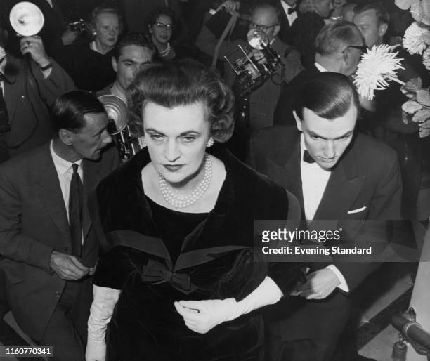 Margaret Campbell, Duchess of Argyll arrives at the Westminster Theatre with her son, Brian Sweeny, London, 10th October 1959. They are attending the...