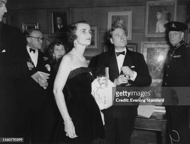 Margaret Campbell, Duchess of Argyll at an exhibition with Mr Lumley-Savile, London, 1st December 1954.