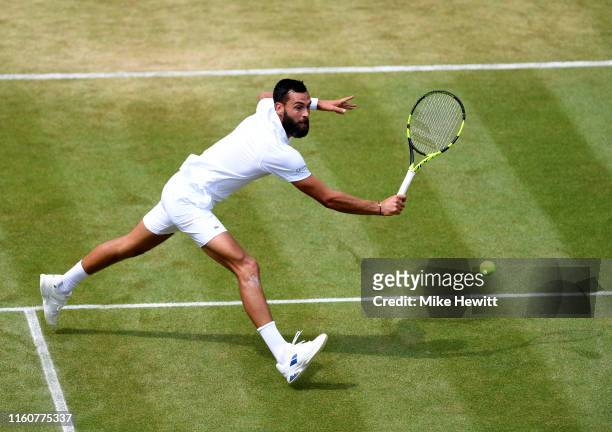 Benoit Paire of France plays a backhand in his Men's Singles fourth round match against Roberto Bautista Agut of Spain during Day Seven of The...