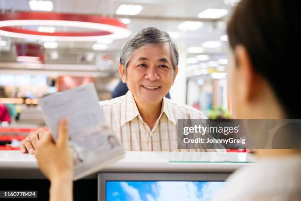 cheerful chinese man having passport checked - portraits of people passport stock pictures, royalty-free photos & images