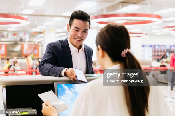 businessman using smartphone at airport check-in counter - showing card stock pictures, royalty-free photos & images