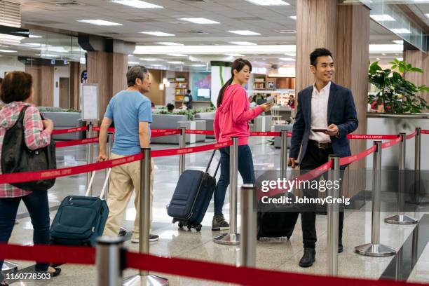 chinese airline passengers with luggage - men in queues stock pictures, royalty-free photos & images