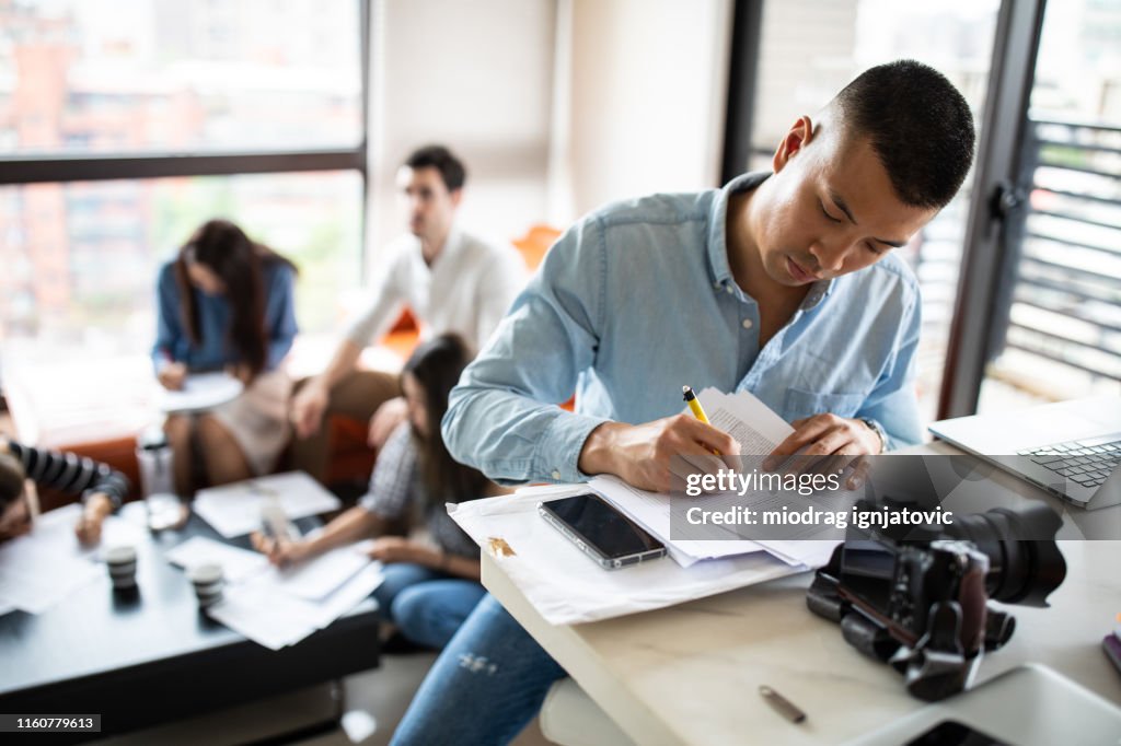 Aziatische fotograaf ondertekening papieren documenten bij Apartment