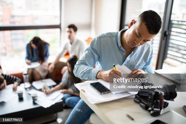 asian photographer signing paper documents at apartment - asian journalist stock pictures, royalty-free photos & images
