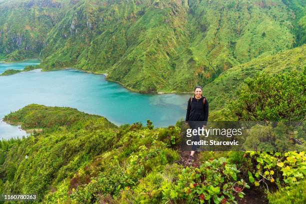 young woman hiker with epic lake background - azores people stock pictures, royalty-free photos & images