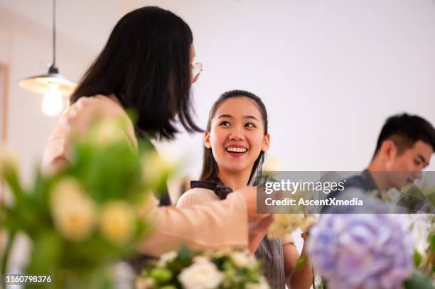 happy woman learning flower arrangement in workshop - floral decoration stock pictures, royalty-free photos & images