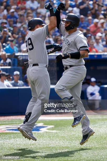 Gary Sanchez of the New York Yankees celebrates his solo home with teammate Gio Urshela during the fourth inning of MLB action against the Toronto...