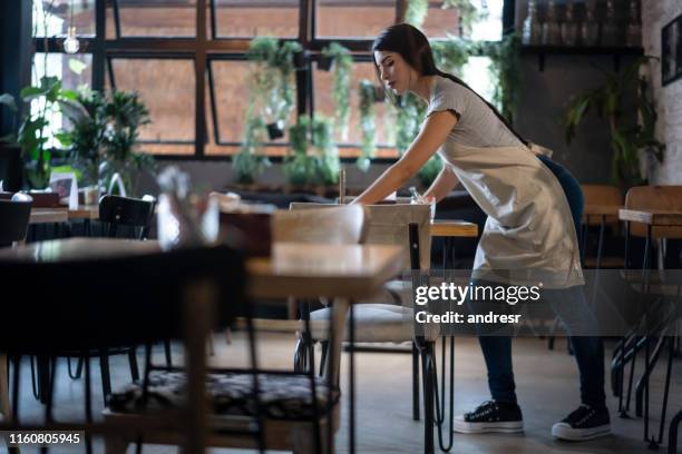 waitress organizing the tables at a restaurant - empregado de mesa imagens e fotografias de stock