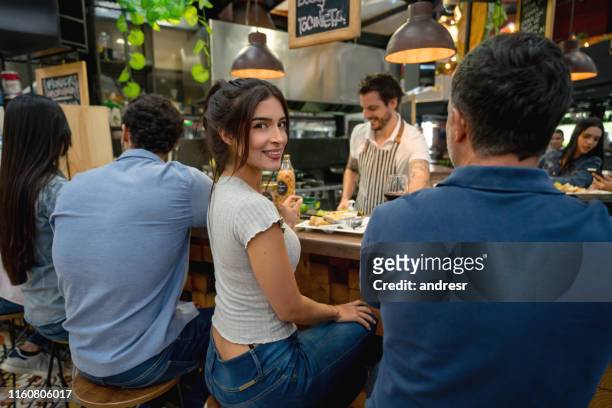 bella donna che mangia alla food court - man eating at diner counter foto e immagini stock