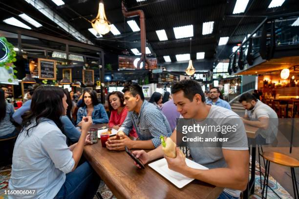 gruppo di persone che pranzano alla food court - man eating at diner counter foto e immagini stock