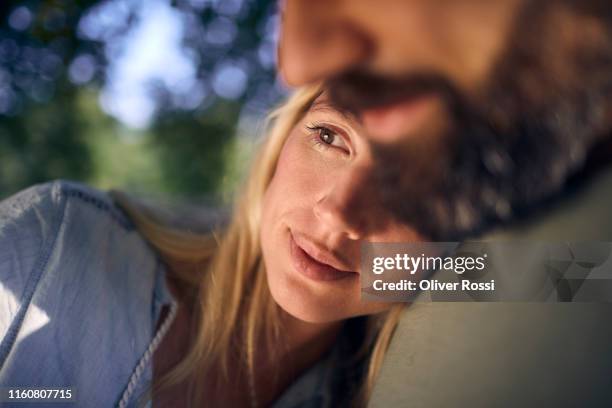 woman leaning against man's shoulder in a park - leaning tree stock pictures, royalty-free photos & images