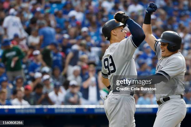 Aaron Judge, left, of the New York Yankees celebrates scoring on Gio Urshela's home run during the sixth inning of MLB action against the Toronto...