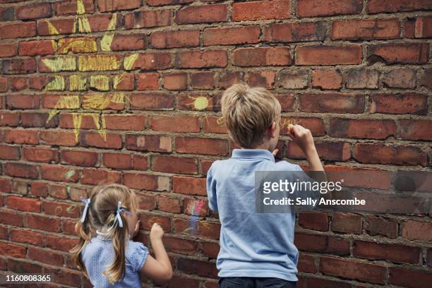 children drawing with chalk - chalk wall stock pictures, royalty-free photos & images