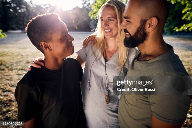 happy family of three in a park - completely bald woman stock pictures, royalty-free photos & images