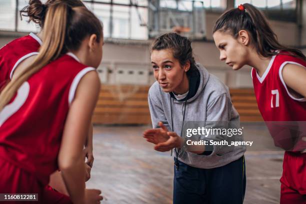 entrenador de pie con el equipo de baloncesto - entrenador fotografías e imágenes de stock