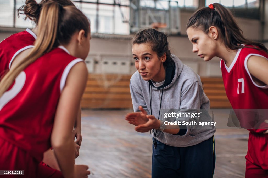 Coach standing with basketball team