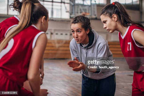 coach standing with basketball team - basketball sport stock pictures, royalty-free photos & images