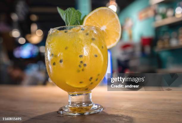 mooie cocktail geserveerd aan de bar - passievrucht stockfoto's en -beelden