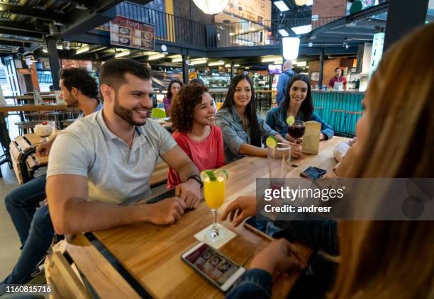 gruppo felice di amici che bevono qualcosa in un ristorante - man eating at diner counter foto e immagini stock
