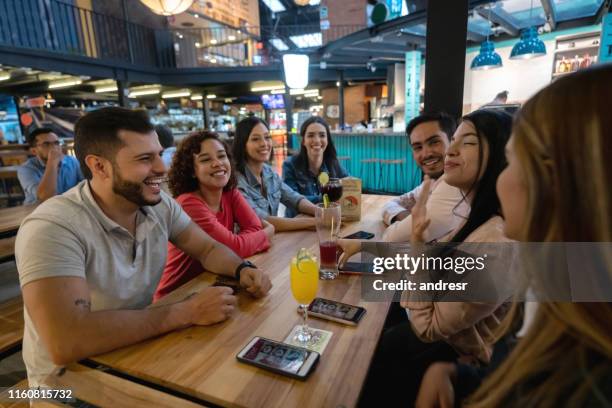 happy group of friends eating at a restaurant - food court stock pictures, royalty-free photos & images