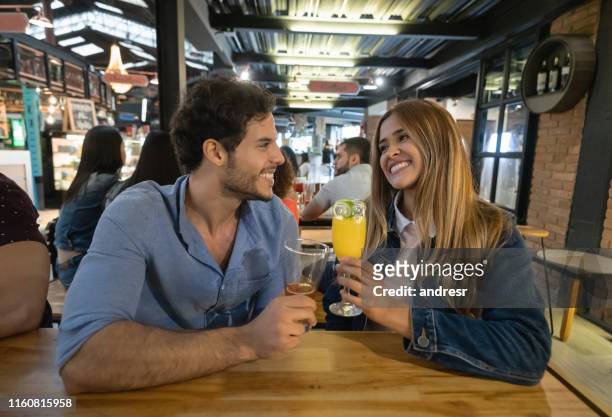 coppia felice che beve un drink in un ristorante - man eating at diner counter foto e immagini stock