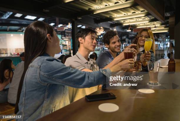 buon gruppo di amici che bevono qualcosa in un bar - man eating at diner counter foto e immagini stock