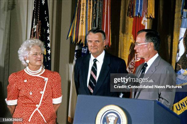 Deputy Director of Central Intelligence Richard James Kerr stands between First Lady Barbara Bush and US President George HW Bush during his...