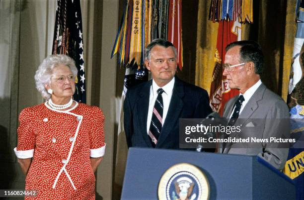 Deputy Director of Central Intelligence Richard James Kerr stands between First Lady Barbara Bush and US President George HW Bush during his...