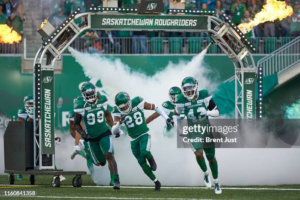 Leonard, Loucheiz Purifoy and Derrick Moncrief of the Saskatchewan Roughriders take the field for the game between the Calgary Stampeders and...