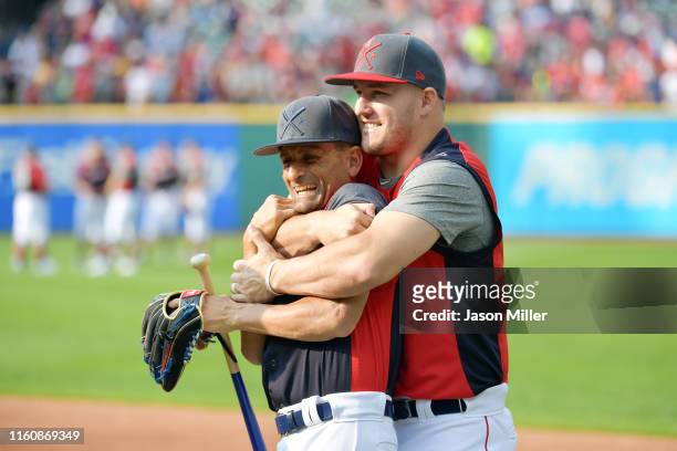 Mike Trout of the Los Angeles Angels of Anaheim and the American League jokes around with Los Angeles Dodgers third base coach Dino Ebel during...