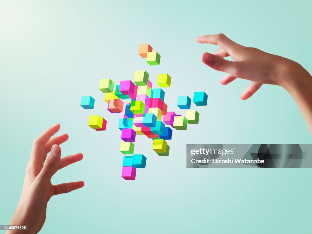 Colorful cubes forming geometric shapes with girls hands