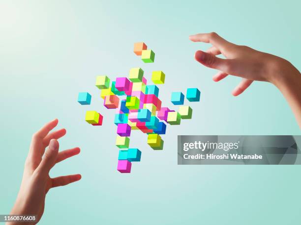 colorful cubes forming geometric shapes with girls hands - block ストックフォトと画像