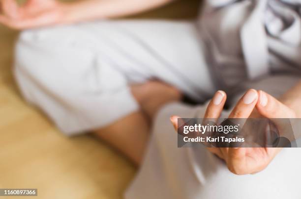 a young woman wearing office clothes is meditating indoor - office wellbeing stock pictures, royalty-free photos & images