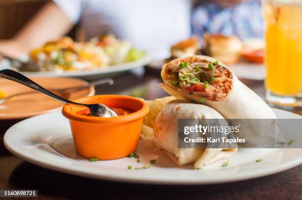 burritos with salsa sauce on a dining table - home made tacos stock pictures, royalty-free photos & images