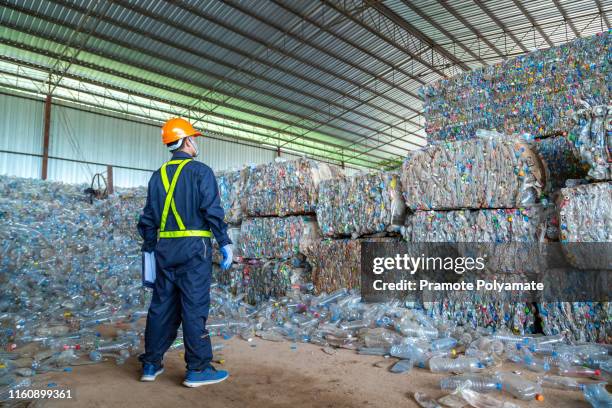 workers in landfill dumping, garbage engineer, recycling, wearing a safety suit standing in the recycling center have a plastic bottle for recycling in the factory. - recycling center ストックフォトと画像