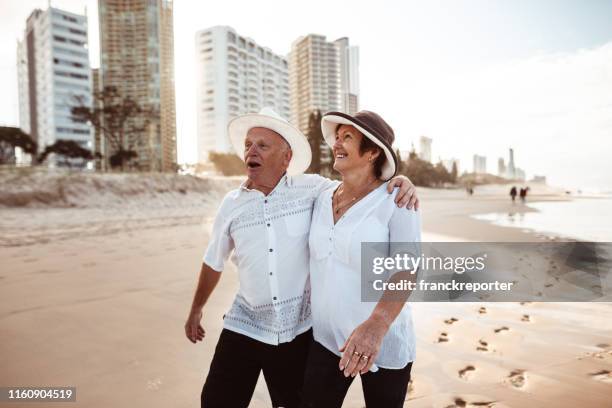 happiness senior couple embracing lovely at dusk - gold coast australia beach stock pictures, royalty-free photos & images