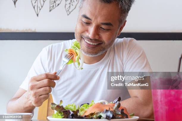 giovane uomo felice che si gode un pasto sano - g man foto e immagini stock