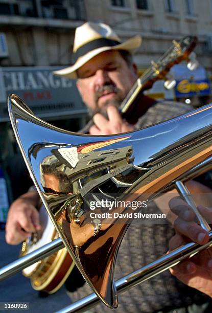 The reflection in Rich Nichol's trombone shows an empty downtown pedestrian mall as he and Elazar Brandt play Dixieland tunes September 10, 2001 in...