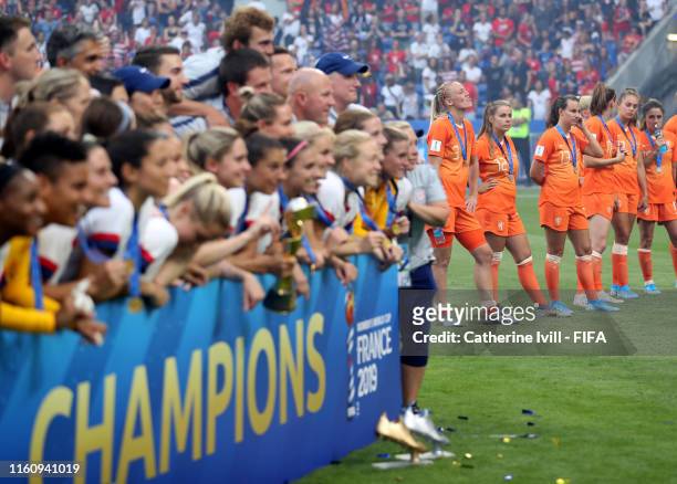 The Netherlands team stand dejected as the USA team celebrate after the 2019 FIFA Women's World Cup France Final match between The United State of...