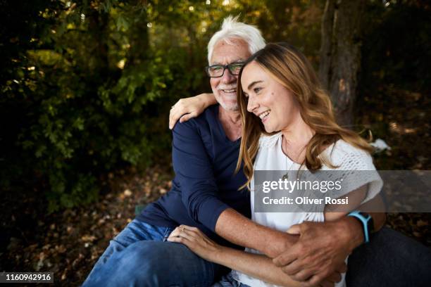 happy father and adult daughter relaxing on a bench in the countryside - enfant adulte photos et images de collection