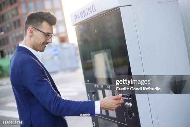 empresario usando un parquímetro - parking meter fotografías e imágenes de stock