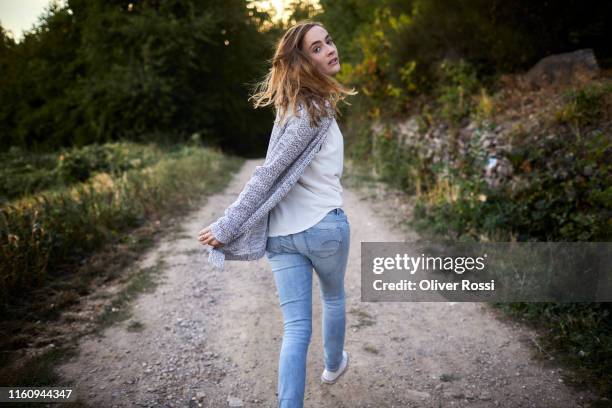 woman walking on a dirt track in the countryside turning round - stalker person stock pictures, royalty-free photos & images