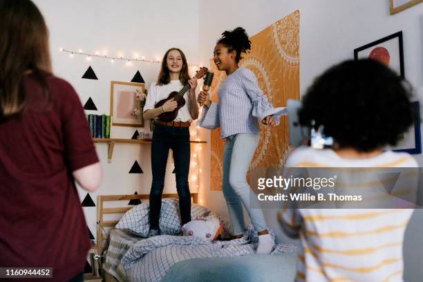 Tween Girls Singing into Hairbrushes at Slumber Party