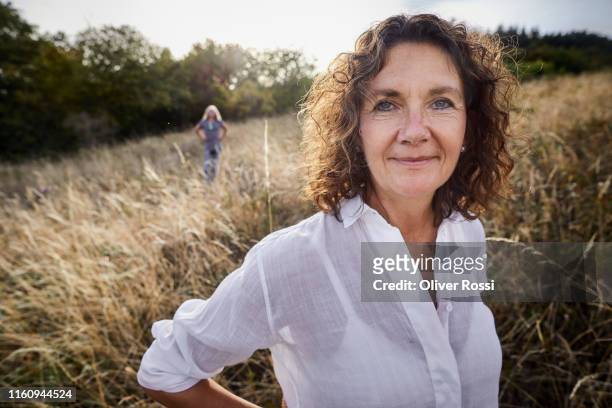 portrait of confident mature woman in a field - woman portrait natural stock-fotos und bilder