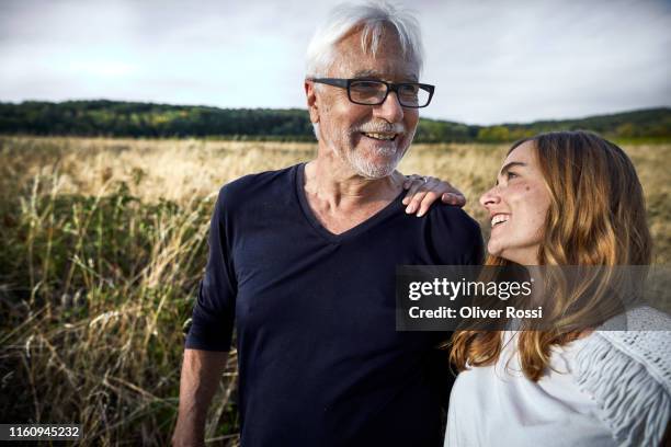 happy father with adult daughter at a field in the countryside - father and grown up daughter stock-fotos und bilder