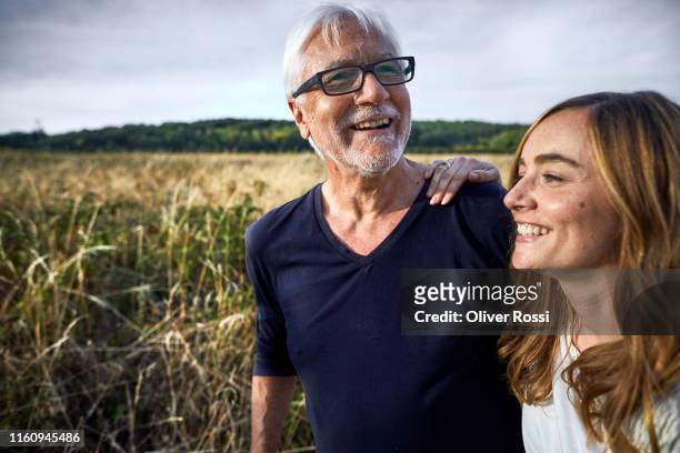 happy father with adult daughter at a field in the countryside - nur erwachsene stock-fotos und bilder